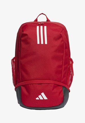 Mochila roja hecha de un tejido duradero, con rayas blancas, de forma redondeada, un bolsillo frontal, bolsillos laterales de malla y un acento negro en la parte inferior.