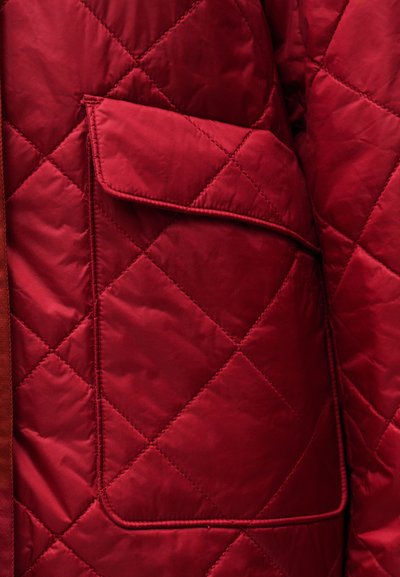 Κόκκινο καπιτονέ μπουφάν με μοτίβο διαμαντιού, με τσέπη με καπάκι στο μπροστινό μέρος και λεία, γυαλιστερή υφή υφάσματος.