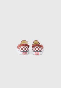 Paire de chaussures Vans slip-on à motif damier rouge et blanc vues de dos sur un fond blanc.