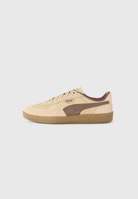 Sneaker in suede beige con accenti marroni, dotate di un design testurizzato, suola in gomma e chiusura con lacci. Logo Puma visibile di lato.
