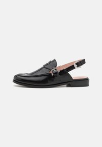 Black patent leather slingback shoe with a rounded toe, decorative strap, and silver buckle accent on the side. Low block heel.