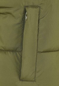 Maslinasto-zeleni puffa jakna sa odvojenim džepom sa zatvaračem i metalnim detaljima, glatkom teksturom i kviltanim dizajnom.