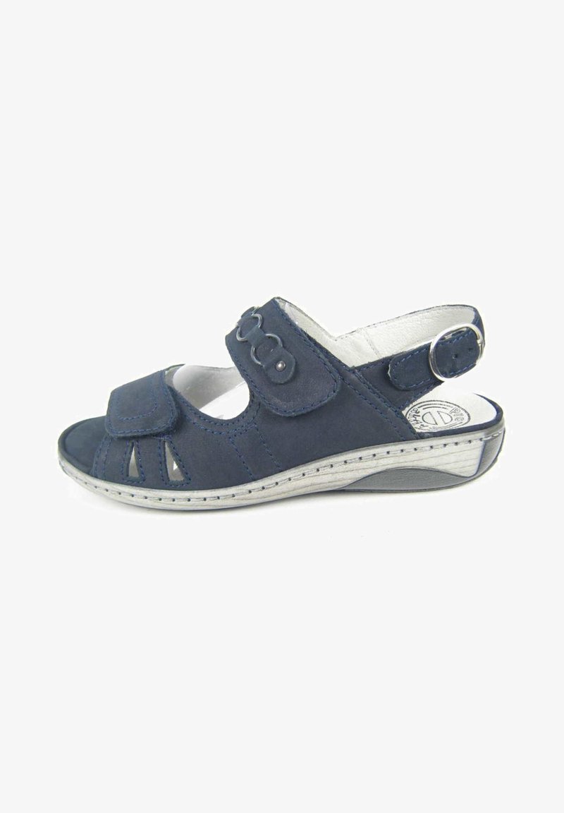Navy-Suede-Sandal mit geschlossenem Zehenbereich, mehreren Ausschnitten, verstellbarem Riemen mit zwei Knöpfen und einer hellgrauen Keilsohle.