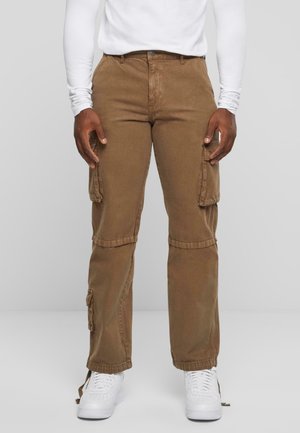 Brown cargo pants with side pockets, made of soft fabric. Features a straight leg design and adjustable cuffs. Worn with white sneakers.