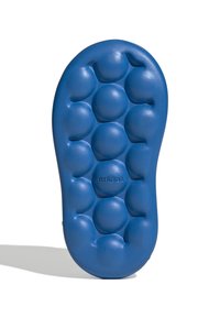 Blauwe schuimzool van een schoen met ronde bultjes voor demping, een gladde textuur en een reliëf merknaam nabij de hiel.