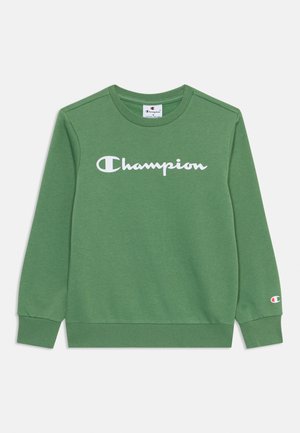 Sudadera verde de algodón, con cuello redondo y mangas largas. Cuenta con un gran logo blanco de "Champion" en el pecho.