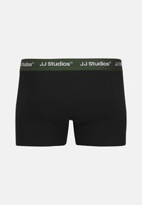 Schwarze Boxershorts mit einem grünen Bündchen, auf dem "JJ Studios" in Weiß gedruckt steht. Glatte Textur und eine enganliegende Passform.