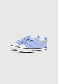 Ζευγάρι ανοιχτό μπλε παιδικά αθλητικά παπούτσια με λευκές λαστιχένιες μύτες, μαύρη ρίγα στις σόλες και δύο λουριά βέλκρο σε κάθε παπούτσι.