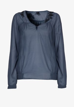 Blå gennemskinnelig bluse med lange ærmer, udsmykket med blomsterdetaljer ved halsudskæringen, nøglehul foran samt detaljer med rynkede manchetter og kant.