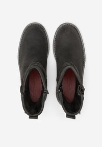 Stivaletti neri alla caviglia con una finitura in suede liscia, pannelli laterali elastici e cuciture a contrasto. Punta arrotondata e linguette per una facile calzata.