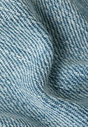 Close-up van zacht, lichtblauw geweven stof met een diagonaal structuurpatroon en zachte plooien.