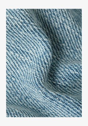 Close-up van zacht, lichtblauw geweven stof met een diagonaal structuurpatroon en zachte plooien.