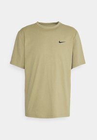 Olivgrön kortärmad t-shirt i bomull med rund halsringning, med en liten svart Nike-logga på vänster bröst. Mjuk textur och avslappnad passform.