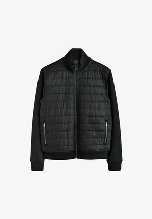 Juodas švarkas su siuvinėtu priekiu, raštuota apykakle ir rankogaliais, turintis užtrauktuku užsegamus šoninius kišenes ir glotnią tekstūrą.