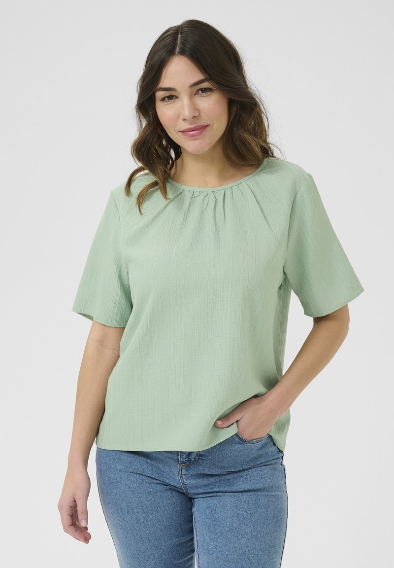 Blusa verde chiaro a maniche corte con scollatura arricciata, realizzata in tessuto testurizzato, caratterizzata da una vestibilità comoda e una finitura liscia.