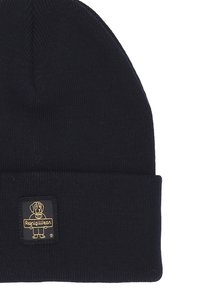 Beanie in maglia nera con risvolto, caratterizzato da una patch rettangolare in tessuto embosso con un grafico dorato di un cane e il nome del marchio.