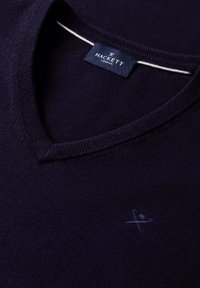 Dunkelblauer V-Ausschnitt-Pullover mit geripptem Kragen, besticktem Logo mit gekreuzten Spazierstöcken und Hut sowie Hackett London Markenetikett im inneren Nackenbereich.