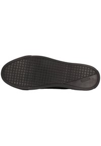 Schwarze Gummisohle mit einem strukturierten Rastermuster, mit runder Schuhspitze und glattem Absatz. Das Markenlogo ist deutlich eingeprägt.
