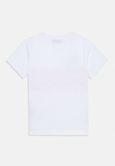 Vit bomullströja med ett vågigt rosa gradientmönster på den nedre ryggen. Korta ärmar och rundad halsringning. Mjuk textur.