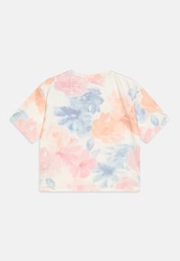 T-shirt à manches courtes avec un motif floral aquarelle en rose pastel, bleu et crème. Tissu doux avec une coupe décontractée et un col rond.