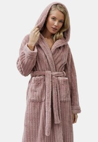 Accappatoio con cappuccio in morbido tessuto rosa testurizzato con motivo a coste, dotato di tasche frontali e cintura annodata per una chiusura sicura.