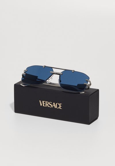 Versace prillid siniste läätsedega, hõbedane metallraam, ristkülikukujuline kuju ja tekstuuriga must kast, millel on brändi nimi kuldsete tähtedega.