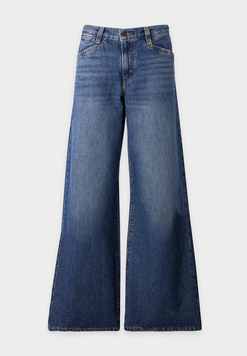 Wijde pijpen jeans in middelblauw denim, met een ritssluiting aan de voorkant, riemlussen en subtiele vervaging op de bovenbenen. Klassiek ontwerp met vier zakken.