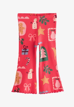 Červené legíny s rebrovanou textúrou, zdobené rôznymi vzormi na tému sviatkov, vrátane snehuliakov, perníkov, darčekov a vianočných stromčekov.