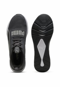 Puma sportsko i sort mesh, med en fremtrædende grå logo rem. Ydersålen har et tekstureret grebsmønster med en hvid accent.
