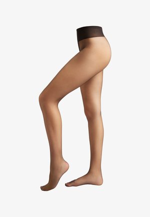 Woman wearing sheer nude pantyhose with black waistband, one foot flat and the other raised on toes, against a white background.