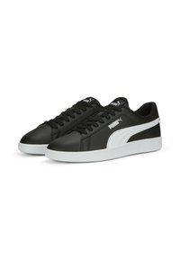 Černé kožené tenisky s bílými detaily, kulatou špičkou, plochou podrážkou a tkaničkami. Na boku a jazyku má výrazné logo Puma.