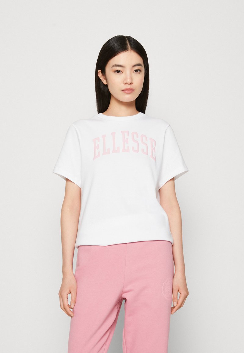 White t-shirt featuring "ELLESSE" printed in light pink, short sleeves, and a crew neck, paired with light pink sweatpants.