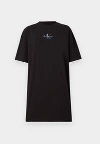 T-shirt noir surdimensionné en coton. Il dispose d'un col rond et de manches courtes. Affiche un logo graphique en bleu et blanc sur le devant.
