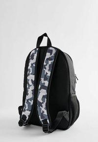 Sac à dos noir avec côtés en mesh et sangles camouflage gris-blanc. Il possède une poignée sur le dessus et une poche zippée sur le côté.