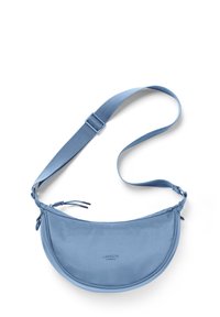 Modrá crossbody taška s krivým tvarom, vyrobená z hladkej látky. Má nastaviteľný popruh a decentné logo značky. Zips na vrchu.