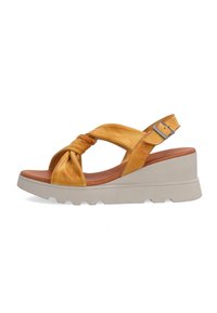 Yellow leather wedge sandals with knotted front, adjustable ankle strap, and textured white sole. Features a smooth, matte finish.