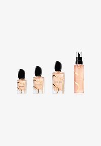 Vier Giorgio Armani parfumflesjes op een rij; drie met zwarte doppen en één sprayfles met een doorzichtige dop, allemaal met perzikkleurige vloeistof erin.