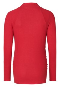 Haut rouge à manches longues en tissu tricot doux. Présente un col rond et des détails froncés sur les côtés, offrant une silhouette ajustée.