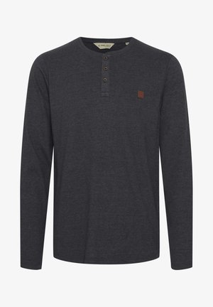 Tumehall pikkade varrukatega särk ümmarguse dekolteega, kolme nööpaukuga ja väikese pruuni logoga plaastriga vasakul rinnal. Pehme kangastekstuuri.