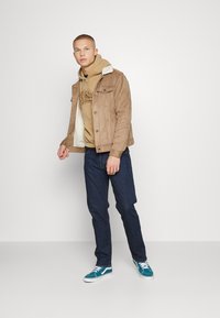 Vintage Supply UNISEX HOODIE WITH VINTAGE SUPPLY RETRO VARSITY LOGO GRAPHIC - Camisola - tan