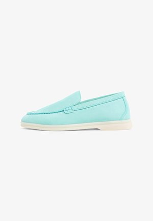 Jasnoniebieskie buty na slip-on z gładką zamszową teksturą, okrągłym noskiem i off-white gumową podeszwą. Minimalistyczne przeszycia wzdłuż krawędzi.