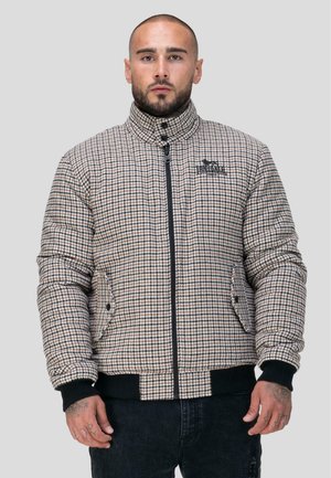 Gevoerde jas met een ruitpatroon in beige en bruine tinten, met een hoge kraag, ritssluiting en zwarte accenten op de mouwen en de zoom.