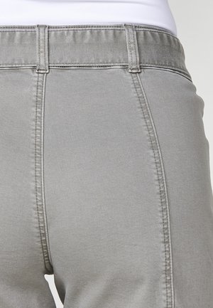 Szürke nadrág puha anyagból, magas derékkal, látható varrással és sima textúrával. Kiegészítők közé tartoznak az oldalsó varrások és a zsebek.