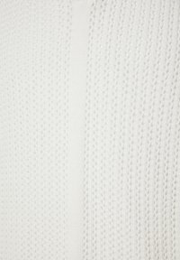 Tissu blanc avec un motif tricoté texturé présentant des rayures verticales alternant entre pleines et perforées.