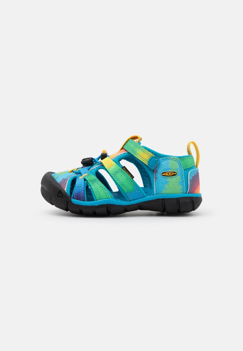 Blå og grønn sporty sandal med åpen design, justerbar stropp, slitesterk såle og et teksturert stoffoverdel med et flerfarget mønster.