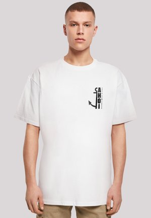 White cotton t-shirt with short sleeves. Features a black text and anchor graphic on the left chest. Relaxed fit, classic crew neck design.