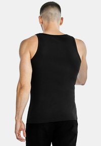 Black tank top made of ribbed material, featuring a close-to-body fit with wide armholes. The back is plain with no visible logos or patterns.