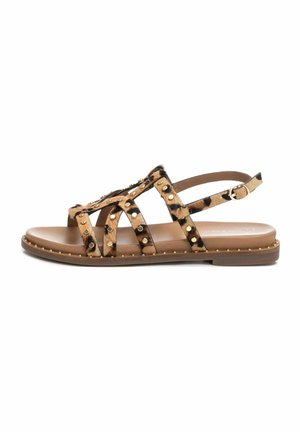 Sandalias marrones y de estampado de leopardo con diseño recortado, acentos de tachuelas y una correa ajustable en el tobillo. Suela plana con una textura suave.