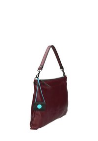 Borsa in pelle bordeaux con finitura testurizzata, una sola tracolla, zip laterale e un piccolo tag nero con un accento blu.