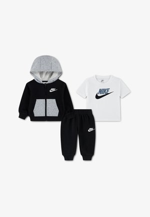 Veste à capuche zippée noire et grise, pantalon noir à taille élastique et T-shirt blanc à manches courtes avec logos Nike.